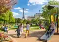 Enfants jouant en famille dans un parc parisien en été