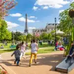 Enfants jouant en famille dans un parc parisien en été